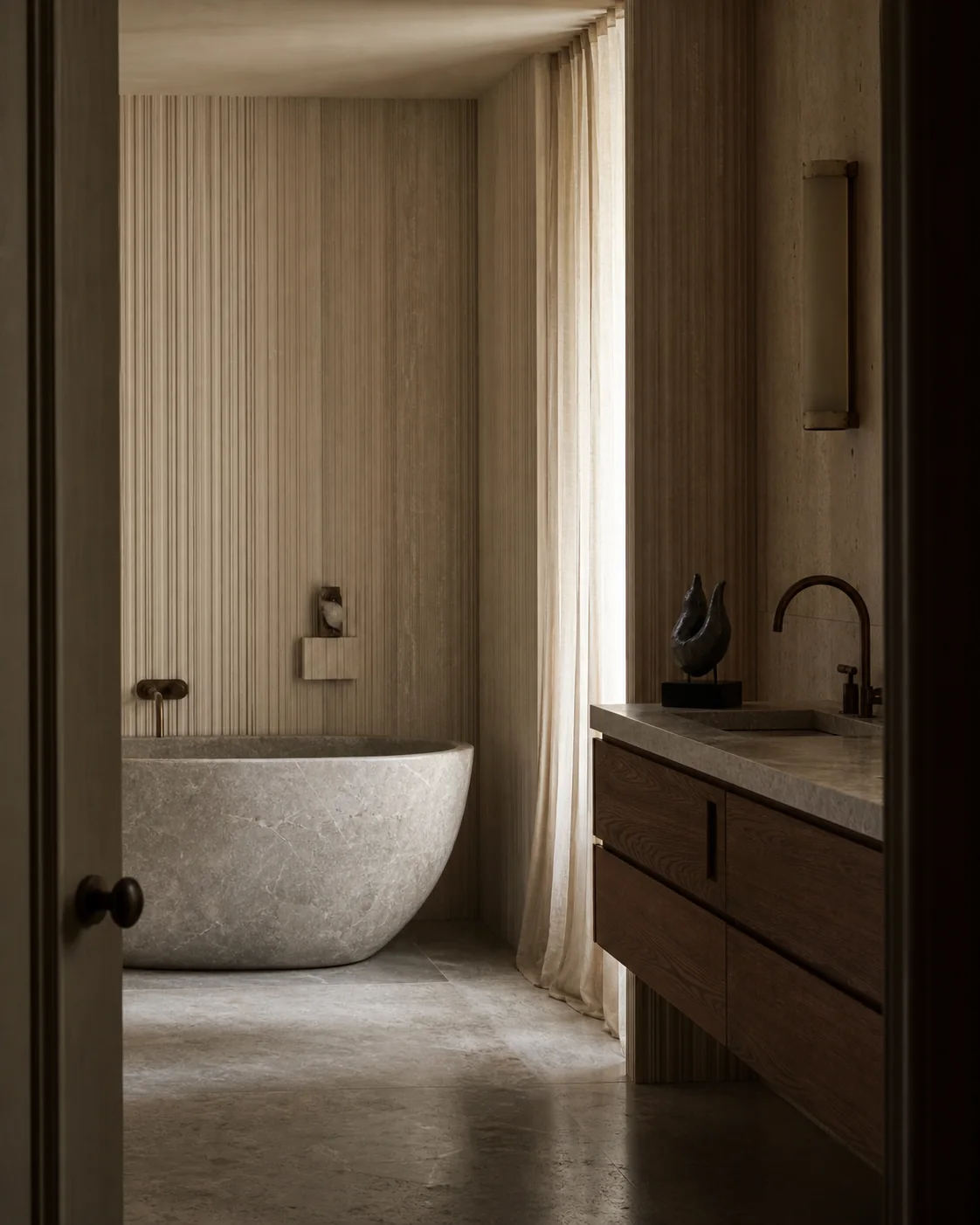 Calm stone bathroom with a freestanding bath and dark wood vanity.