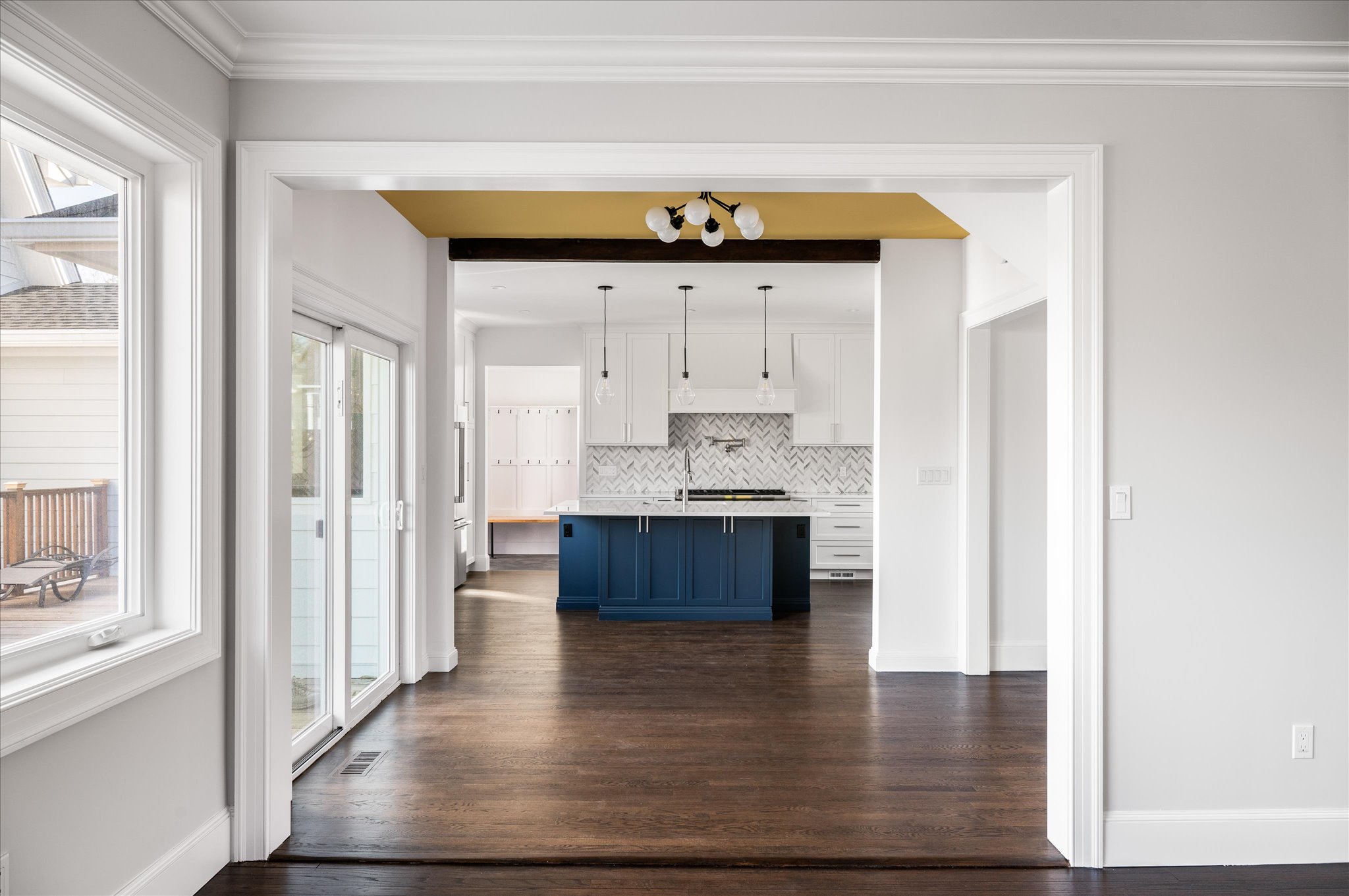 View through the dining room into the bright kitchen and navy island.